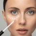 A lady putting under eye concealer for mature skin on.